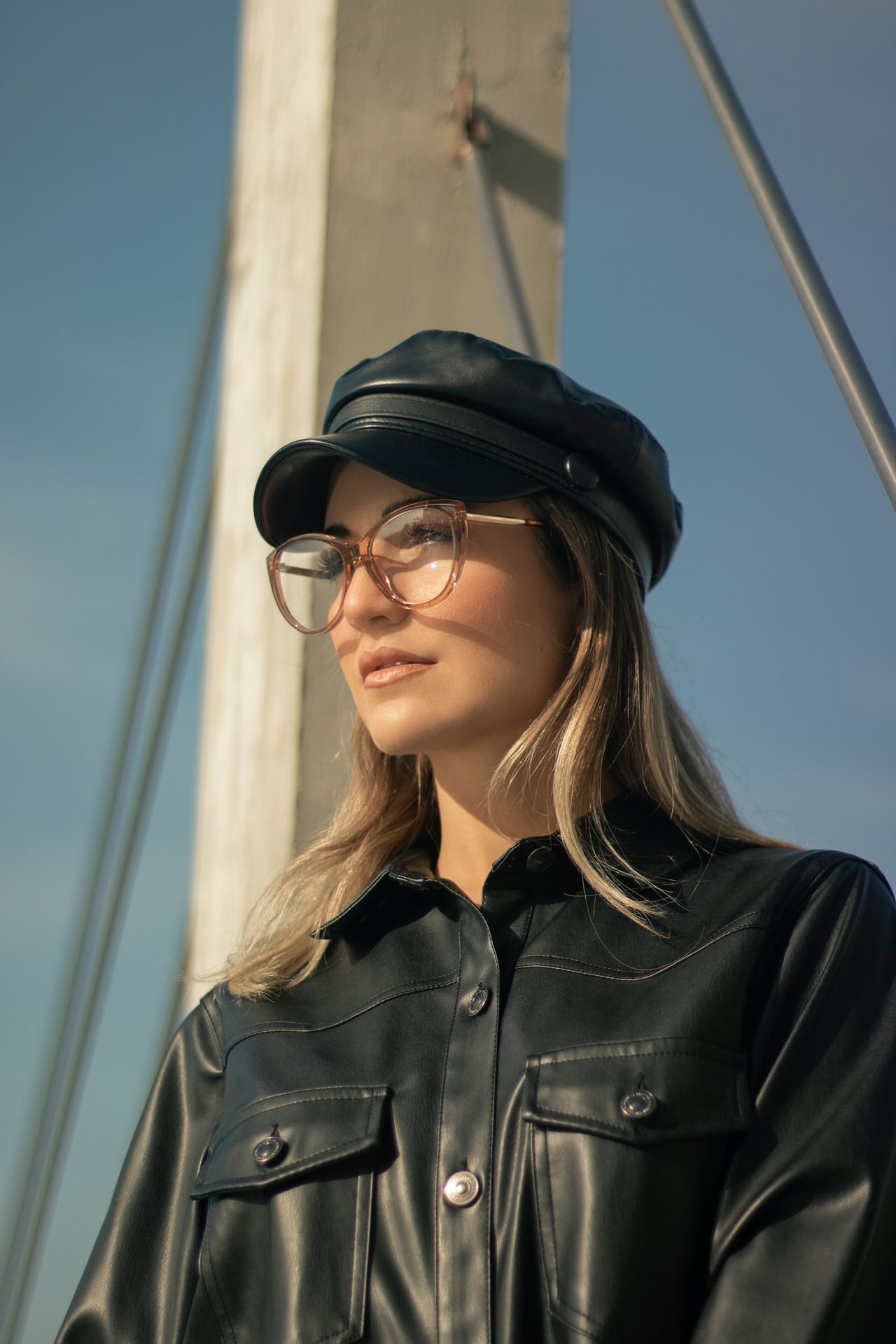 a woman wearing a black leather jacket and hat